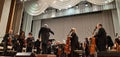 Photo conductor and musicians. Musical concert in the Philharmonic. Violin player. Music concert background