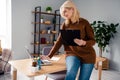 Photo of confident busy business woman at office in brown sweater working using laptop research market updates holding Royalty Free Stock Photo