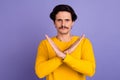 Photo of confident focused young man crossed arms demonstrate stop symbol isolated on violet color background Royalty Free Stock Photo