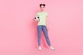 Photo of confident girl hold soccer ball look camera wear green t-shirt jeans footwear isolated on pink background Royalty Free Stock Photo