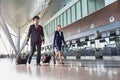 Portrait of confident pilot with stewardess walking in airport