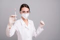Photo of confident pretty young lady doctor workwear glasses mask making you anti corona virus injection isolated grey Royalty Free Stock Photo