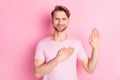 Photo of confident pretty young man wear casual outfit rising hand palm arm swear tell truth pink color