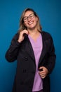 Photo of a confident smiling female doctor dressed in a black coat and lilac uniform, wearing eyeglasses, looking into the camera Royalty Free Stock Photo