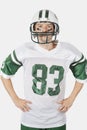 Portrait of confident young man wearing football uniform against gray background