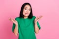 Photo of confused guilty adorable girl with bob hairdo dressed green t-shirt shrugging shoulders isolated on pink color