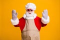 Photo of confused santa grandpa chef headwear bake cookery raise hands gloves open mouth tried help did wrong move wear