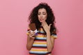 Photo of confused woman 20s with curly hair holding chocolate ba