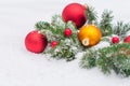 Photo of the coniferous branches decorated with three big toys for the Christmas tree lying in the snow Royalty Free Stock Photo