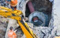 Photo of construction or active repair water supply, sewer or pipe drainage system in concrete pit by workers in orange vests with Royalty Free Stock Photo