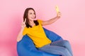Photo of cool brunette hair millennial lady sit do selfie show v-sign wear yellow t-shirt jeans isolated on pink