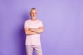 Photo of cool old man beaming smile folded arms look camera wear pink trousers t-shirt isolated violet color background Royalty Free Stock Photo