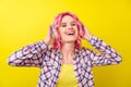 Photo of cool pink hairdo young lady hear music wear plaid shirt isolated on yellow color background