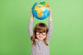 Photo of cool small blond hair girl hold globe up wear striped shirt isolated on green color backgound