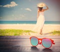 photo of cool sunglasses on the young woman on the coast background