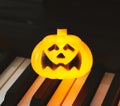 Photo with copy space of one Halloween pumpkin light decorated on piano keyboard Royalty Free Stock Photo