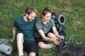 Photo of couple and a dog sitting in forest at summer with backpacks Royalty Free Stock Photo
