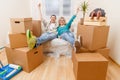 Photo of couple sitting on couch among cardboard boxes