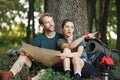 Photo of couple sitting in forest at summer with backpacks Royalty Free Stock Photo