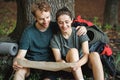 Photo of couple sitting in forest at summer with backpacks Royalty Free Stock Photo