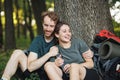 Photo of couple sitting in forest at summer with backpacks Royalty Free Stock Photo