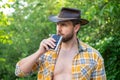 photo of cowboy man drink bourbon hipflask. cowboy man with bourbon hipflask.