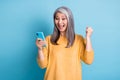 Photo of crazy ecstatic old woman use smartphone impressed social media like feedback win raise fists scream yes wear Royalty Free Stock Photo