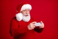 Photo of crazy excited old man in santa claus headwear use smartphone enjoy x-mas jolly holly newyear ads wear sweater