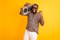 Photo of crazy handsome dark skin guy hold shoulder retro tape recorder raise fist cool holidays rest relax wear shorts
