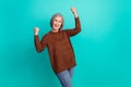 Photo of crazy overjoyed aged lady raise fists success luck shout yes isolated on teal color background Royalty Free Stock Photo