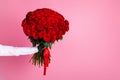 Photo of cropped man arm hold big one hundred red bright roses bunch giving girlfriend surprise not show face secret