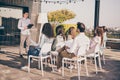 Photo of crowd of sitting people listen to recruitment manager hold clipboard tell about tasks outdoors