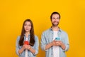 Photo of cuning millennial brown hairdo couple with telephone look promo wear jeans shirt isolated on yellow background