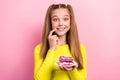 Photo of cunning tricky schoolgirl wear yellow top finger lips mouth holding cake piece plate isolated pink color