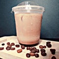 photo a cup of brewed coffee next to coffee beans on a wooden platter