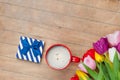 Photo of cup of coffee, cute gift and colorful tulips