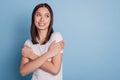 Photo of curious dreamy lady cuddle shoulders look up empty space on blue background