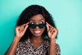 Photo of curious lady take off sunglass look empty space wear leopard print shirt isolated teal color background