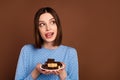 Photo of curious short hairdo young lady hold chocolate look empty space wear blue blouse isolated on brown color