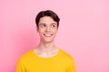 Photo of curious smart guy look empty space think thoughts wear yellow t-shirt isolated on pink background