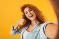 Photo of curly attractive woman 20s smiling and showing thumb up