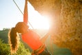 Photo of curly-haired female tourist clambering over rock Royalty Free Stock Photo