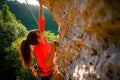 Photo of curly-haired female tourist clambering over rock Royalty Free Stock Photo