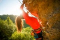 Photo of curly-haired female tourist clambering over rock Royalty Free Stock Photo