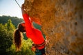 Photo of curly-haired female tourist clambering over rock Royalty Free Stock Photo