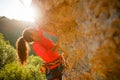 Photo of curly-haired female tourist clambering over rock Royalty Free Stock Photo