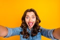 Photo of curly wavy cheerful charming nice girl sticking tongue out taking selfie playful isolated over yellow vivid Royalty Free Stock Photo