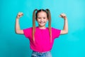 Photo of cute adorable active strong girl wear stylish clothes showing her power biceps triceps muscles isolated on cyan Royalty Free Stock Photo