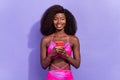 Photo of cute adorable afro girl wear pint sexy outfit communicating modern gadget smiling isolated purple color Royalty Free Stock Photo