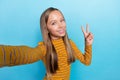 Photo of cute adorable girl make selfie arm fingers demonstrate v-sign  on blue color background Royalty Free Stock Photo